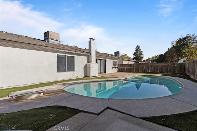 view of swimming pool featuring a diving board and a patio