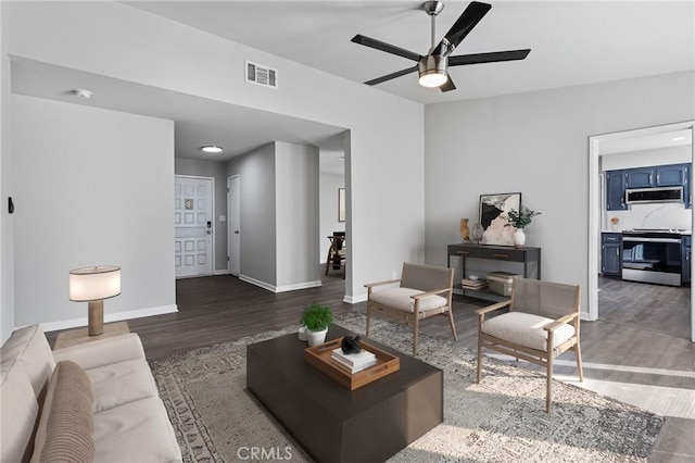 living room featuring dark wood-type flooring and ceiling fan