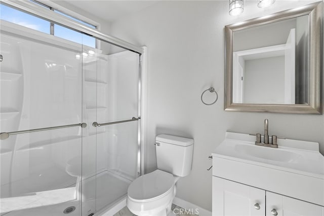 bathroom with vanity, toilet, and a shower with door