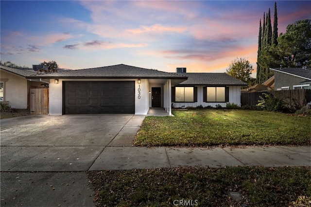 view of front of house featuring a garage and a lawn