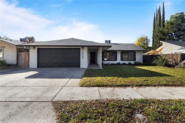 ranch-style house featuring a garage and a front yard