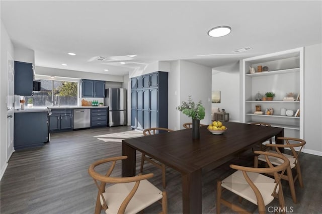 dining room featuring sink, built in features, and dark hardwood / wood-style floors