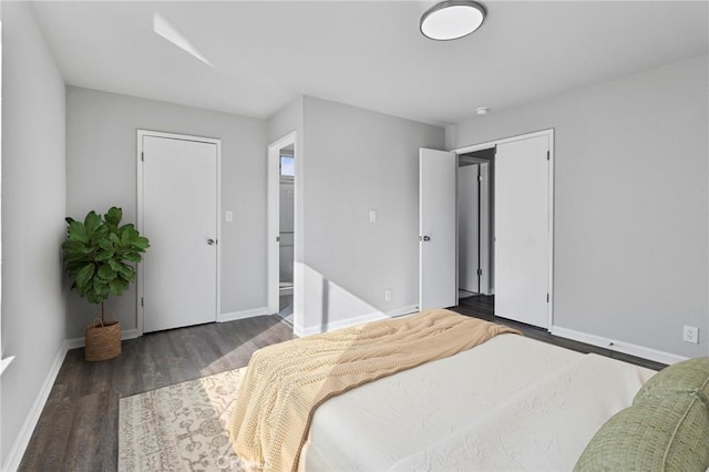 bedroom with dark hardwood / wood-style flooring and ensuite bath