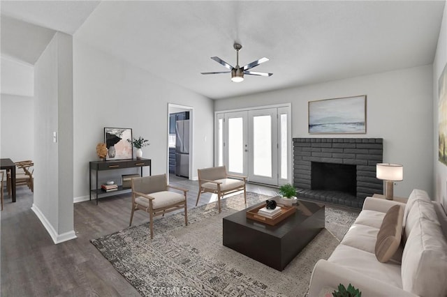 living room with a fireplace, dark hardwood / wood-style floors, ceiling fan, and vaulted ceiling