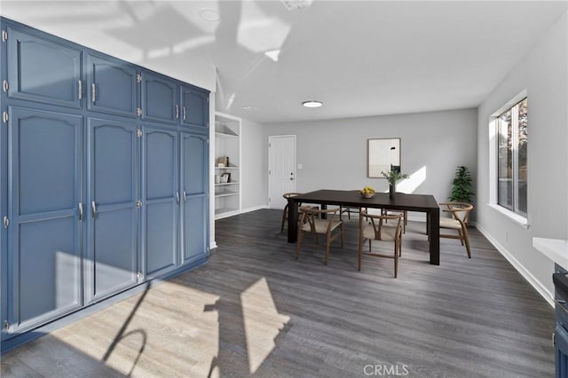 dining area featuring built in shelves and dark hardwood / wood-style floors