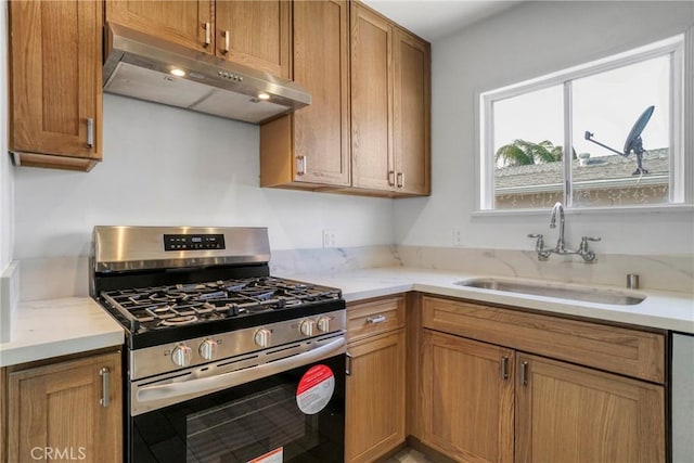 74357437 Balcom Ave, Reseda, CA 91335 - kitchen with under cabinet range hood, gas range, a sink, light stone counters, and brown cabinetry