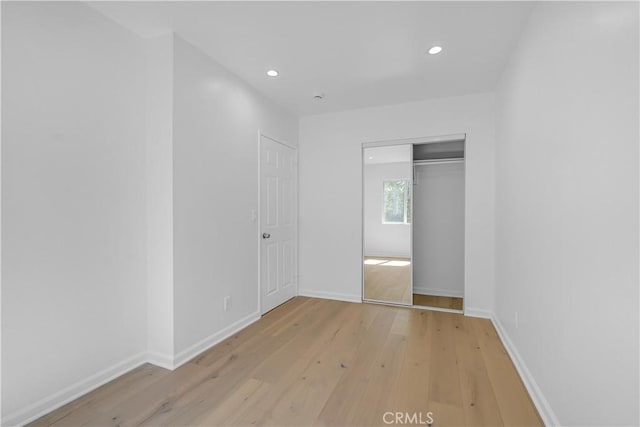 unfurnished bedroom featuring light hardwood / wood-style floors and a closet