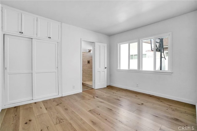 unfurnished bedroom featuring light hardwood / wood-style floors and a closet