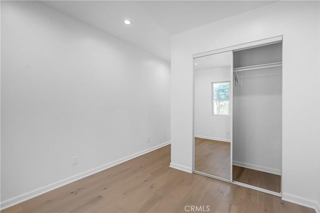 unfurnished bedroom featuring light hardwood / wood-style floors and a closet