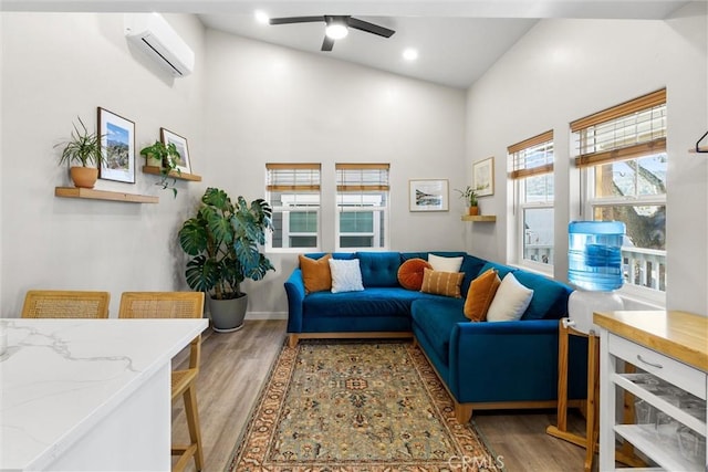 living area featuring ceiling fan, recessed lighting, wood finished floors, a towering ceiling, and a wall mounted air conditioner