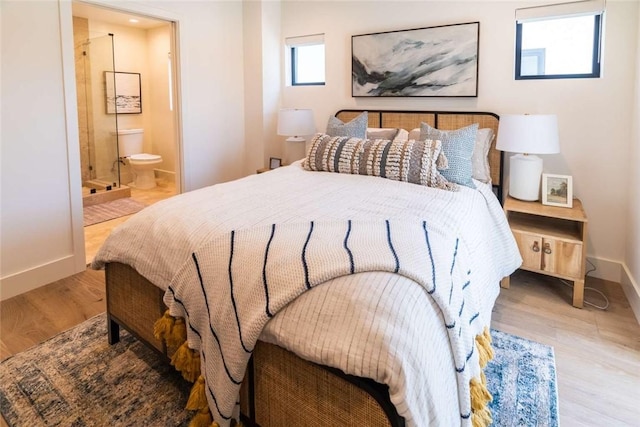 bedroom featuring ensuite bathroom and light hardwood / wood-style flooring