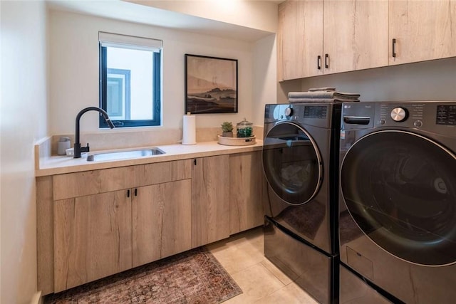 washroom with cabinets, washing machine and clothes dryer, sink, and light tile patterned floors