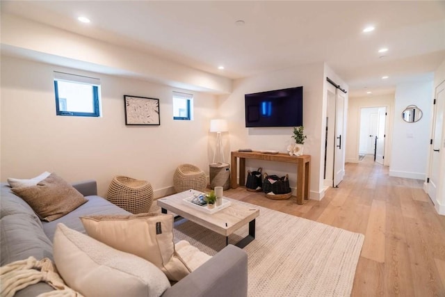 living room featuring a barn door and light hardwood / wood-style flooring