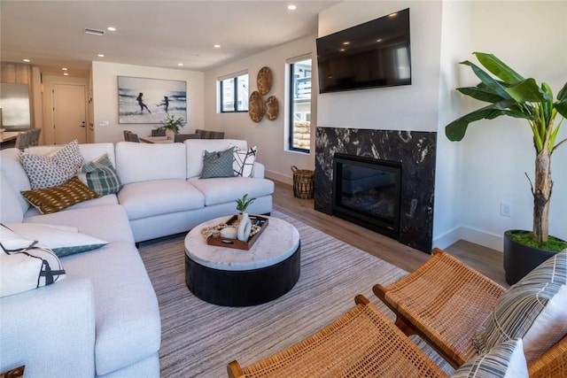 living room featuring hardwood / wood-style flooring and a high end fireplace