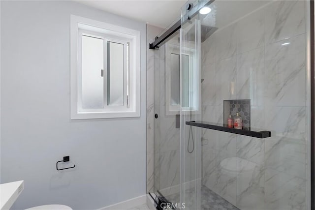 bathroom with a shower with shower door and toilet