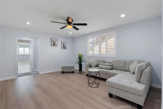 living room featuring ceiling fan and light hardwood / wood-style flooring