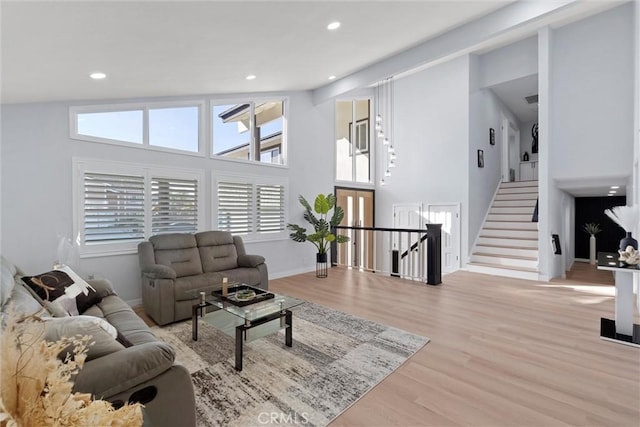 living room featuring high vaulted ceiling and light hardwood / wood-style floors