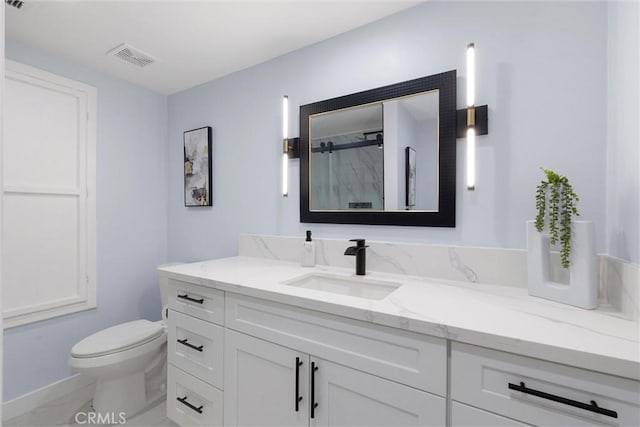 bathroom with vanity, toilet, and a shower