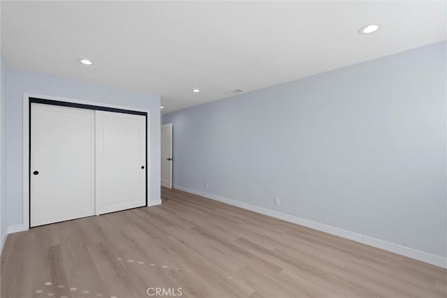 unfurnished bedroom with a closet and light hardwood / wood-style flooring