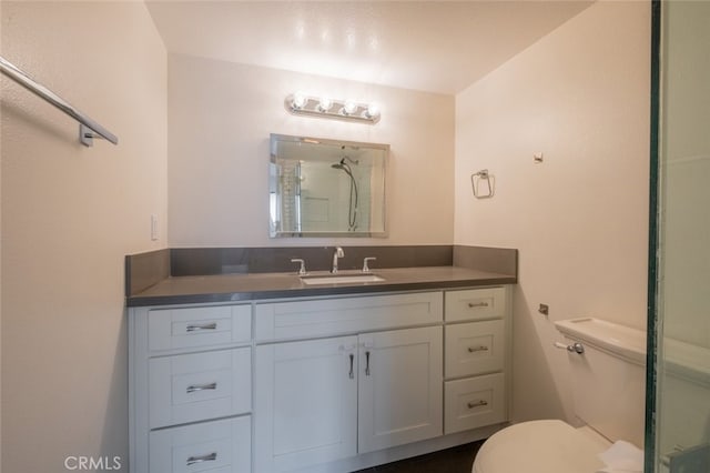 bathroom featuring toilet, vanity, and walk in shower