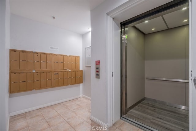 interior space featuring elevator, tile patterned flooring, and a mail area