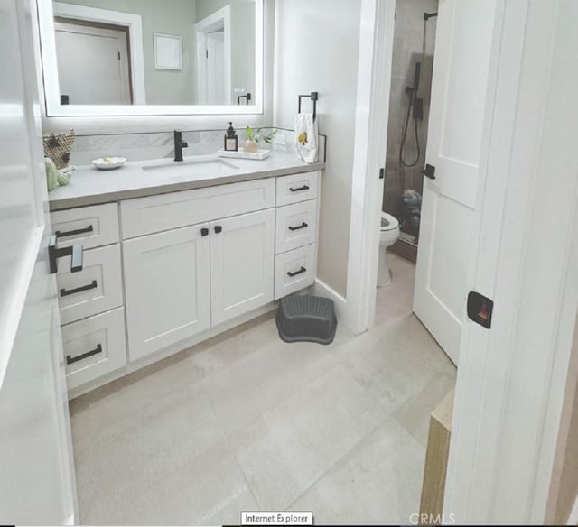 bathroom featuring toilet, walk in shower, and vanity