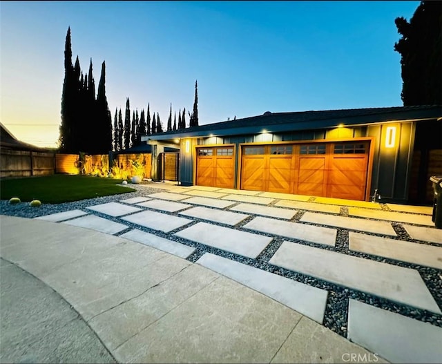 garage at dusk featuring a yard