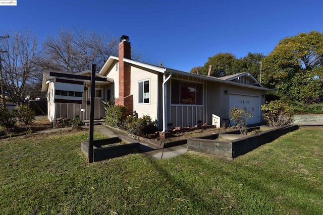 back of property featuring a garage and a yard