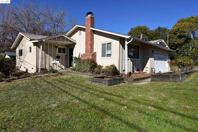 back of house with a yard and a garage