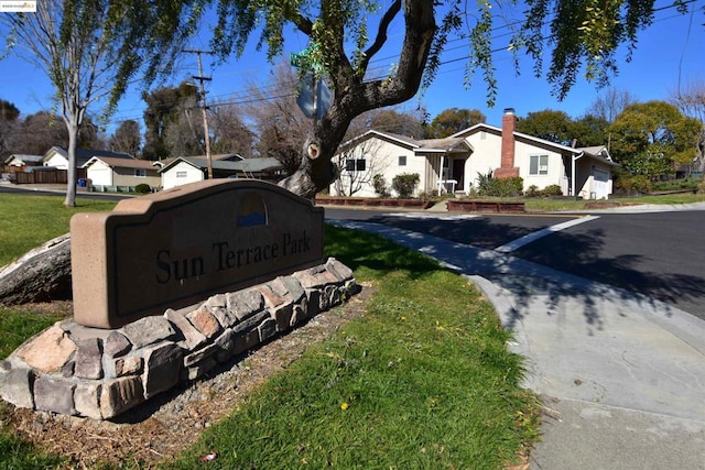 community / neighborhood sign featuring a lawn