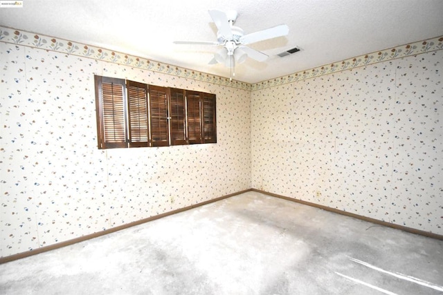 spare room featuring a textured ceiling, carpet flooring, and ceiling fan