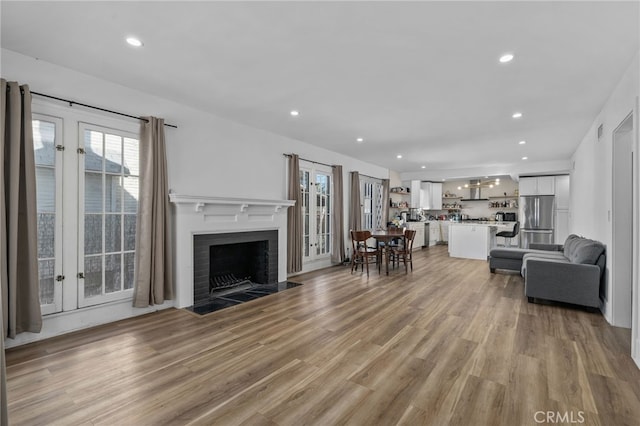 unfurnished living room with light hardwood / wood-style flooring and a brick fireplace