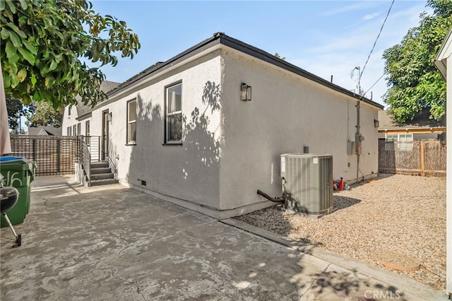 view of side of home with cooling unit and a patio