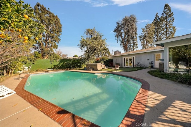 view of swimming pool with a patio area and a hot tub