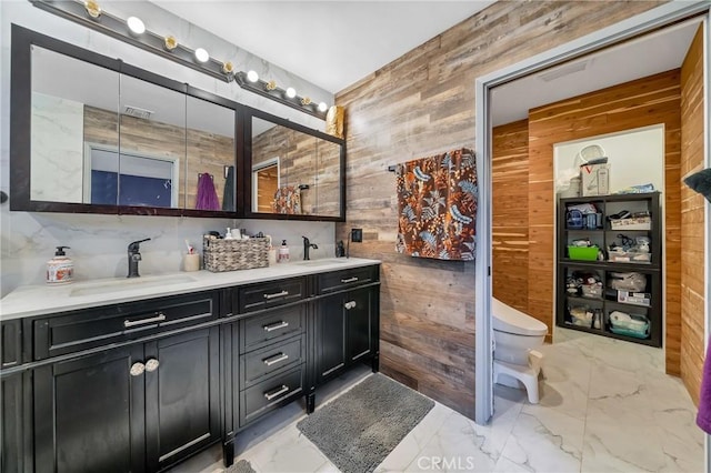 bathroom featuring wood walls, toilet, and vanity