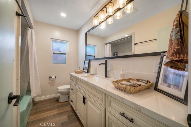 full bathroom with vanity, toilet, shower / tub combo with curtain, and wood-type flooring