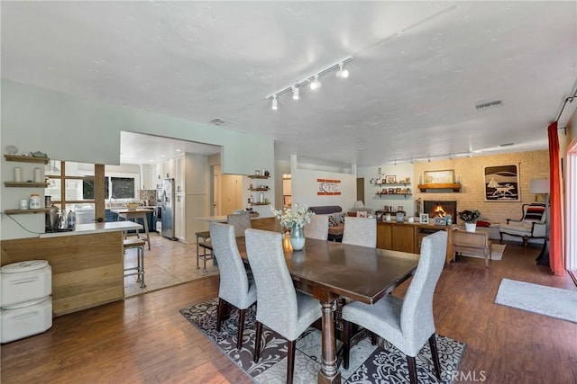 dining space with hardwood / wood-style floors and a fireplace