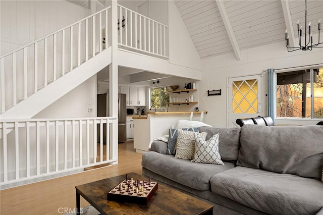 living room with high vaulted ceiling, wooden ceiling, beam ceiling, and light wood-type flooring