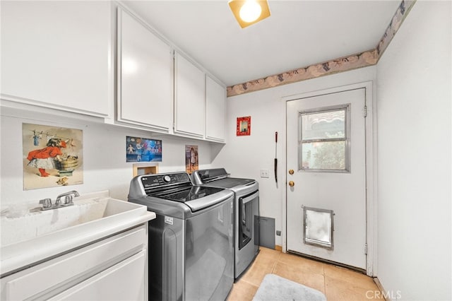 laundry area with light tile patterned floors, cabinets, and washer and dryer