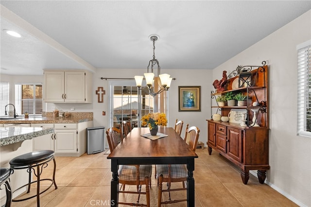 dining area featuring light tile patterned flooring, sink, and a healthy amount of sunlight