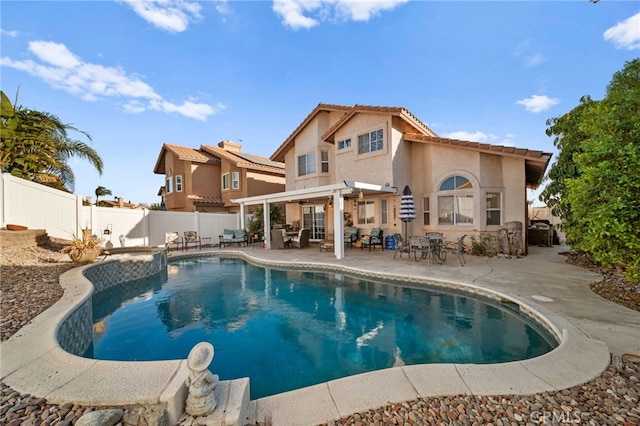 rear view of house featuring a fenced in pool and a patio