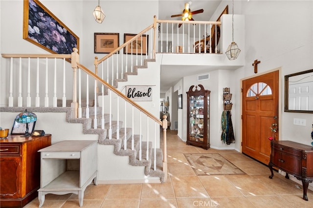 tiled entrance foyer featuring a high ceiling and ceiling fan