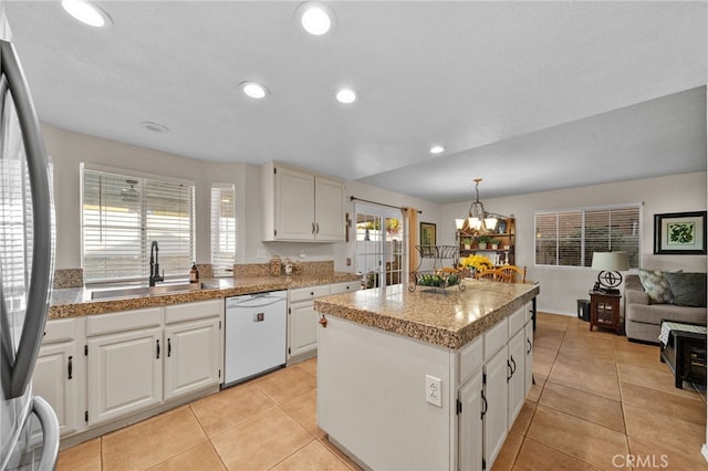 kitchen featuring dishwasher, a center island, white cabinetry, stainless steel fridge, and light tile patterned floors