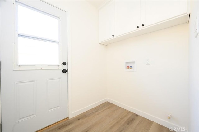 clothes washing area featuring hookup for a washing machine, light hardwood / wood-style floors, and cabinets