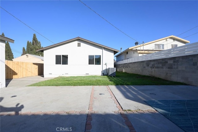 rear view of property featuring a patio, a yard, and cooling unit