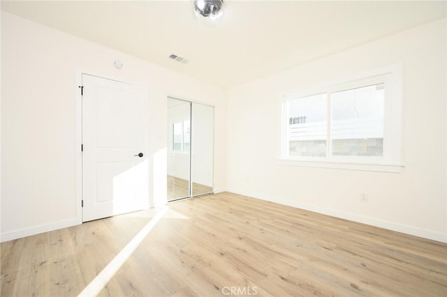 unfurnished bedroom featuring light hardwood / wood-style floors and a closet