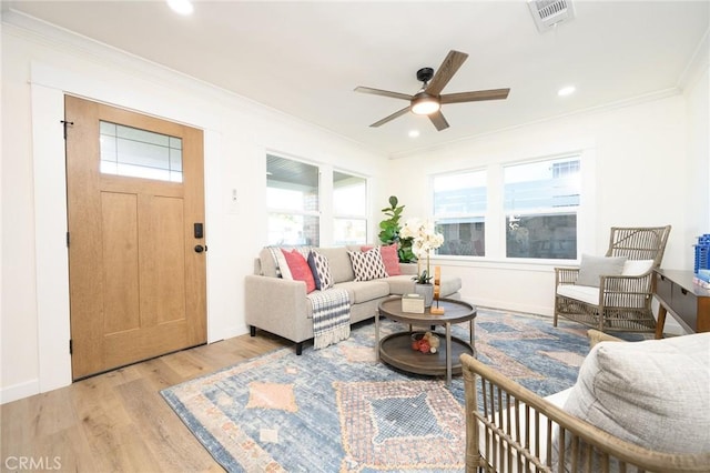 living room featuring ceiling fan, ornamental molding, and light hardwood / wood-style floors