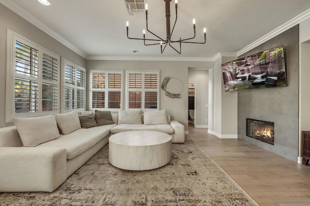 living room with crown molding, hardwood / wood-style floors, and an inviting chandelier