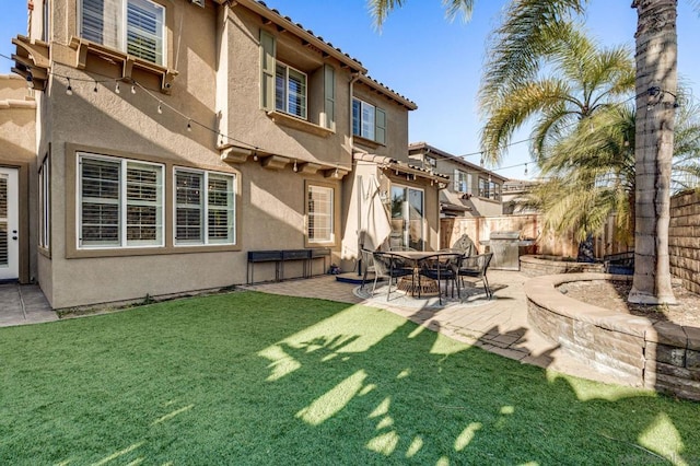 back of house featuring a lawn and a patio area