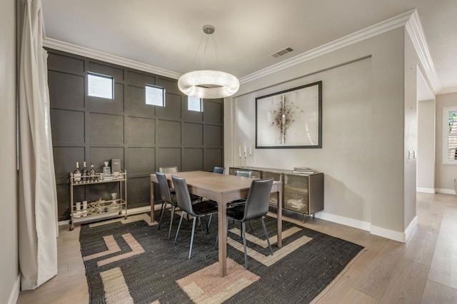 dining area with hardwood / wood-style flooring and ornamental molding